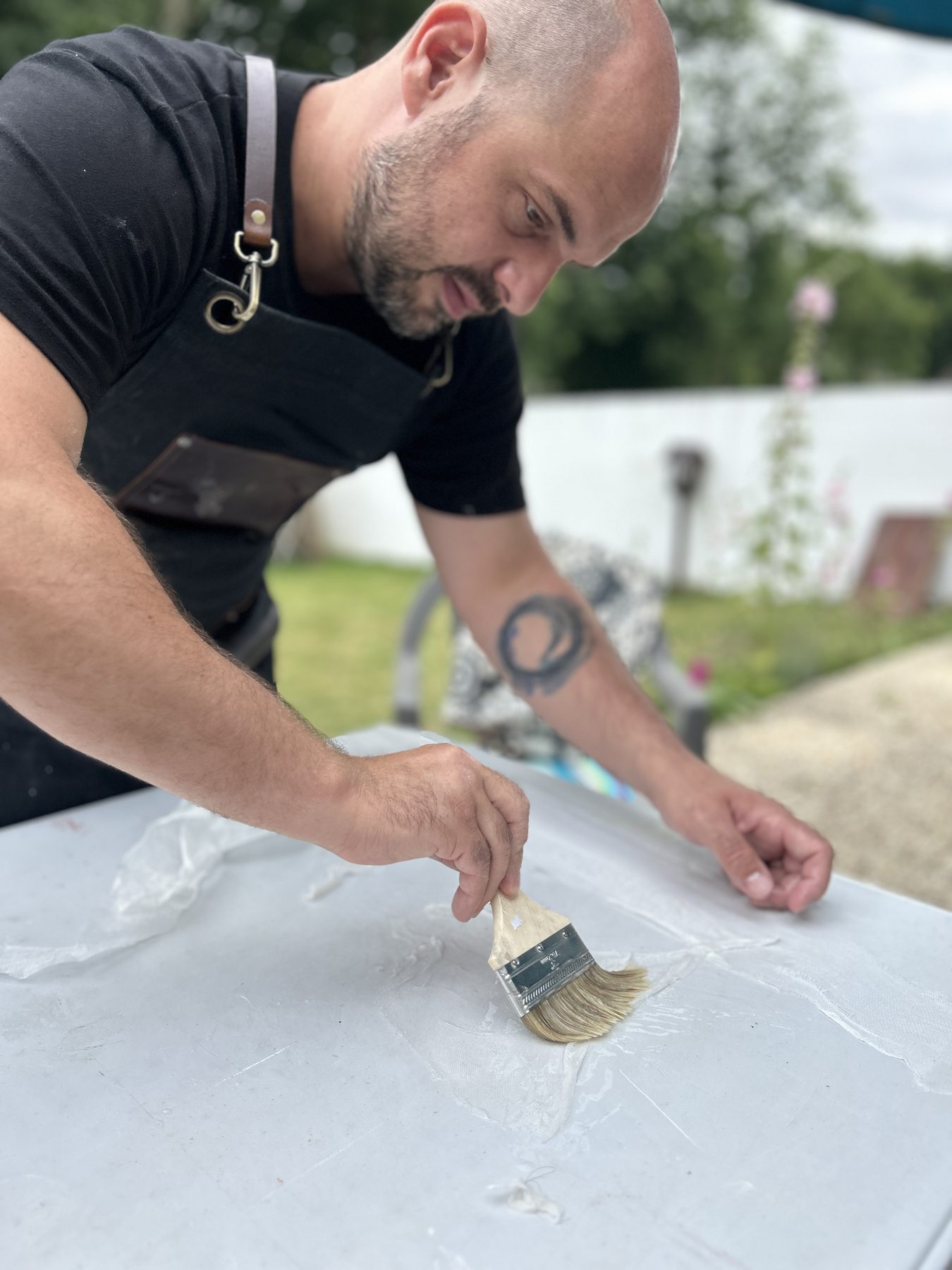 Ghyslain Kuehn pasting paper at his workbench