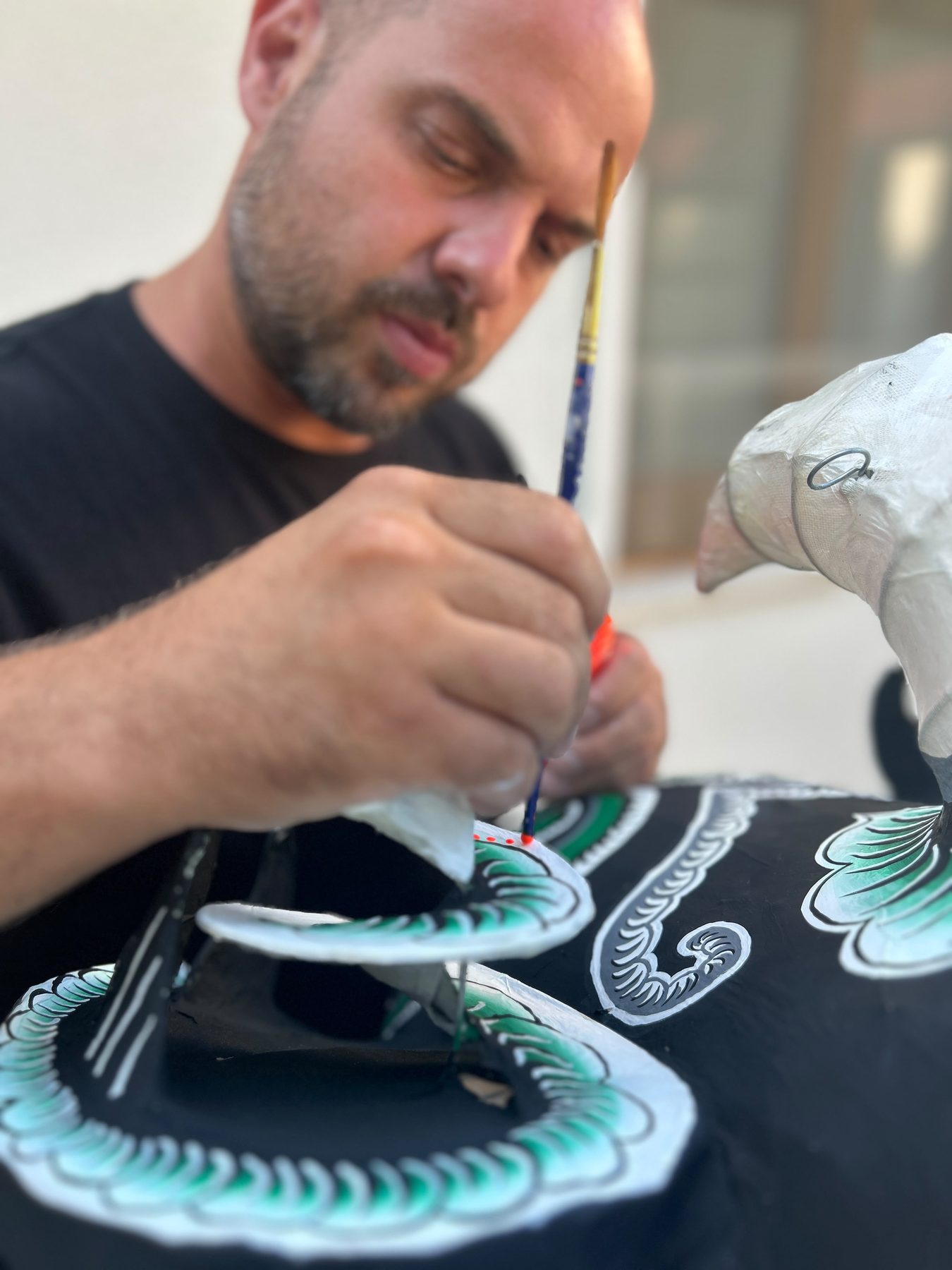 Painting motifs on a lion head with a fine brush