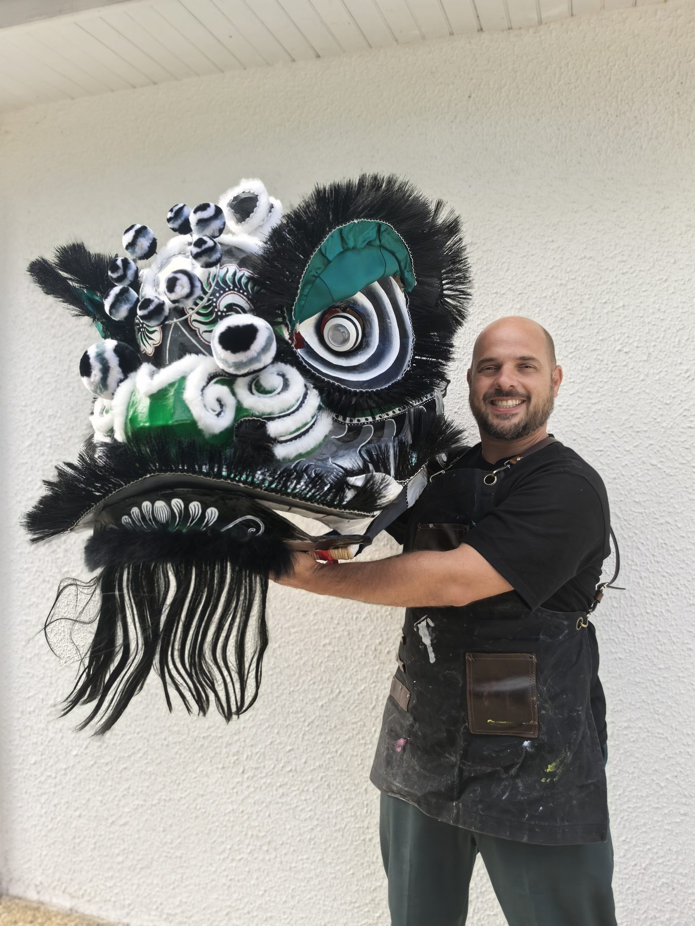 Ghyslain Kuehn holding a black and white lion head