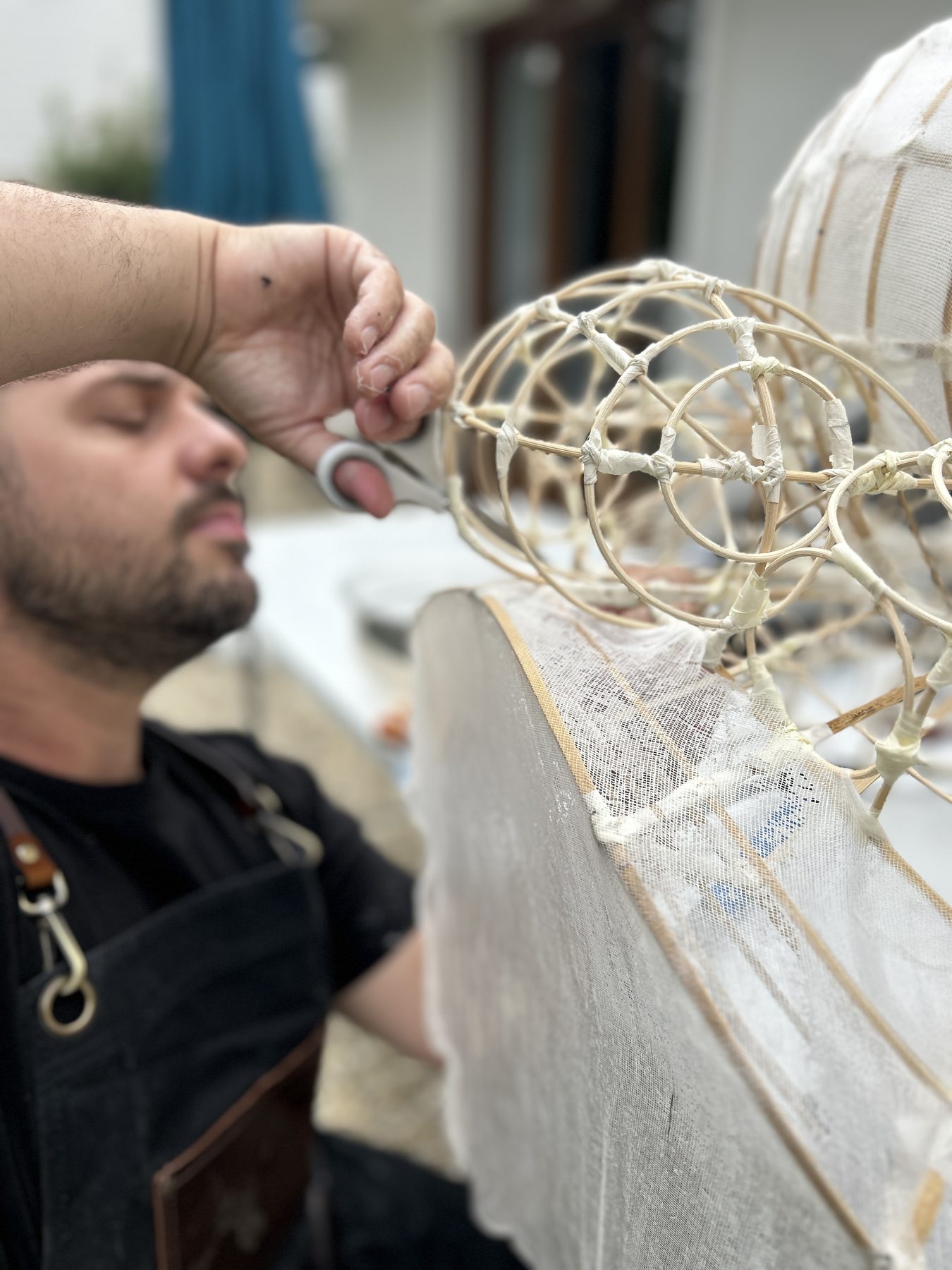 Ghyslain Kuehn trimming paper on a bamboo frame